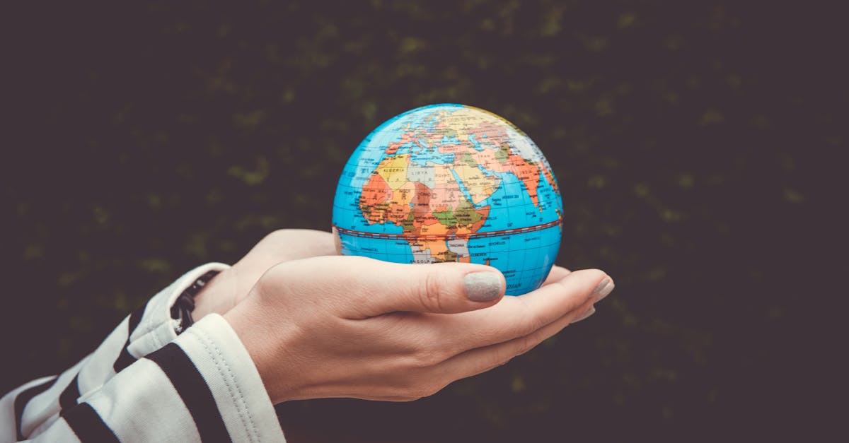 Person holding a small globe in hands, showcasing Earth. Ideal for global concepts or travel themes.